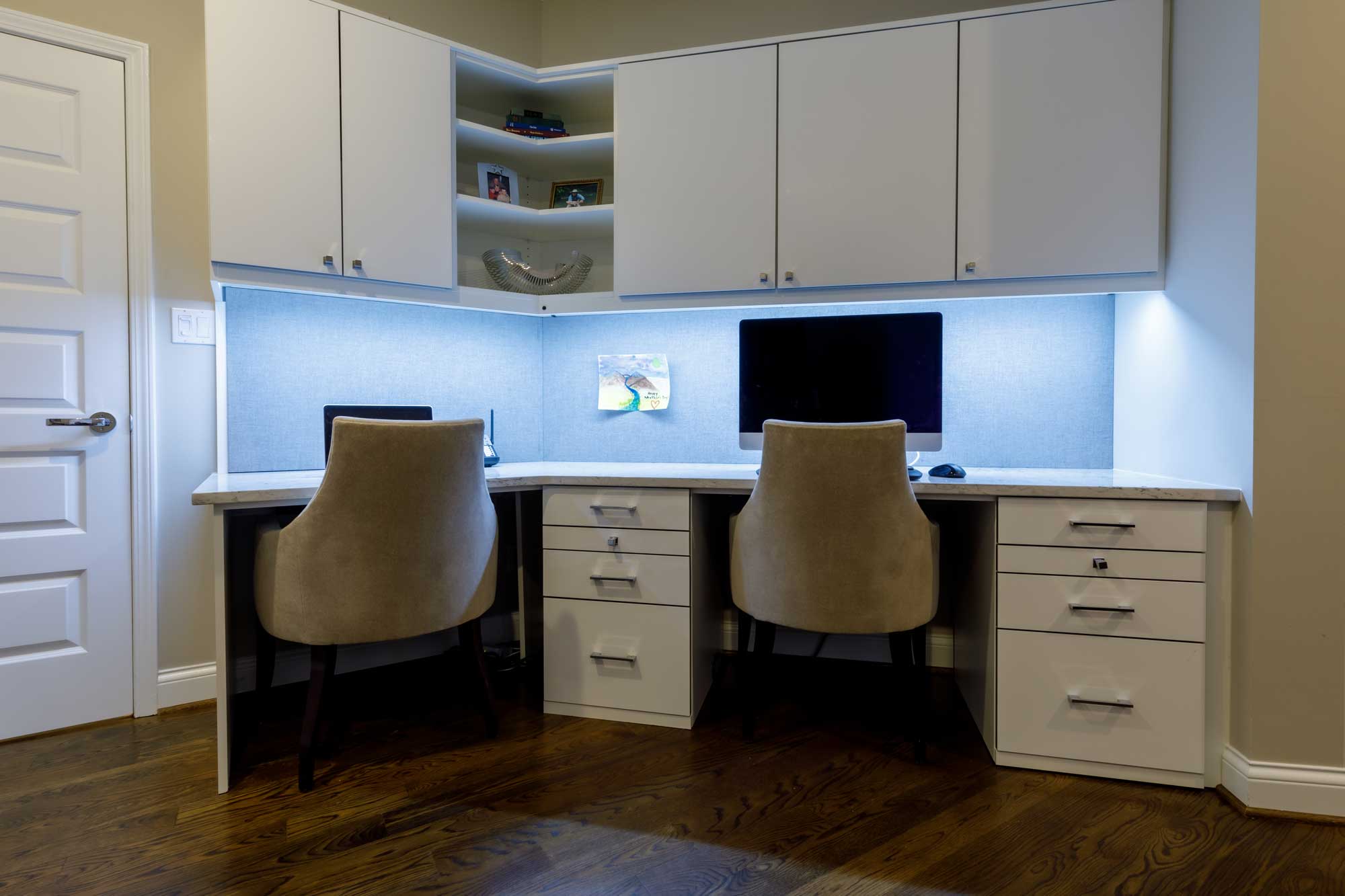 Home office with white cabinets above office desk